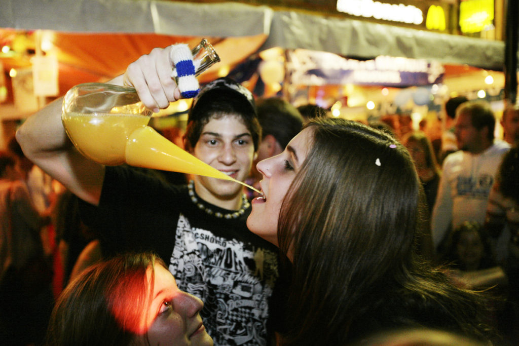 Grape Harvest Festival in Neuchâtel. A young boy offers to a young girl a mixing of orange juice and strong alcohol drinks. - 2006