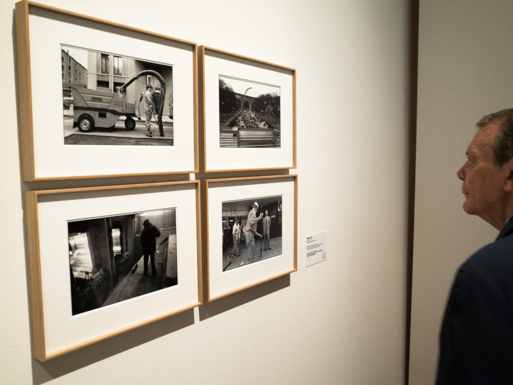 Switzerland. Geneva. Musée Rath. A visitor is looking at my four pictures on garbage collectors. May 26th, 2016